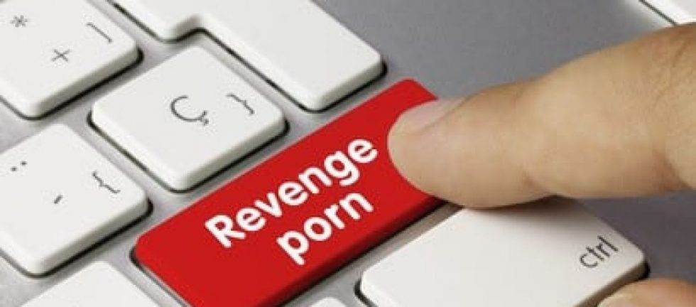 Finger pressing a red button labeled "Revenge porn" on a keyboard.