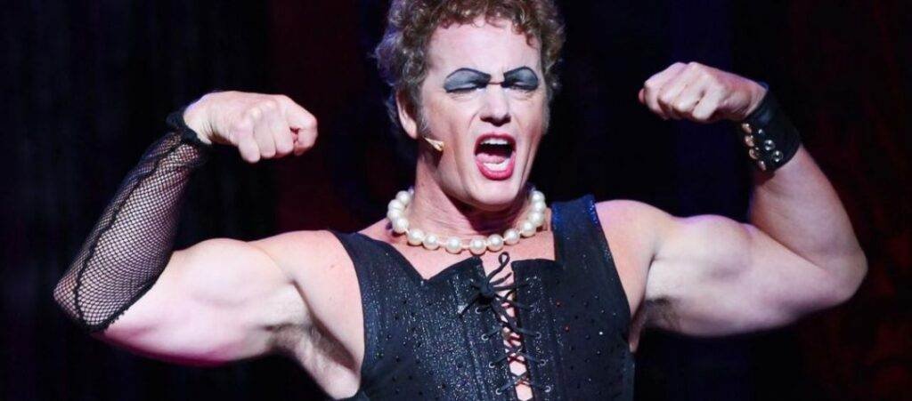 Craig McLachlan in character, flexing biceps.