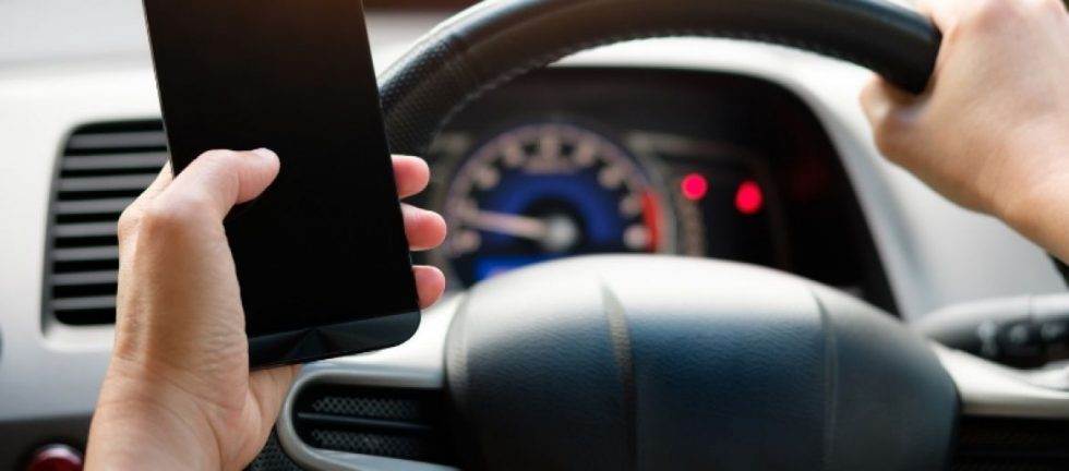 Driver holding mobile phone while driving in NSW.
