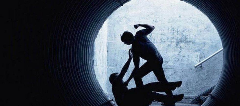 Silhouetted figures in a dark tunnel; one person appears to be assaulting another. Assault offences.