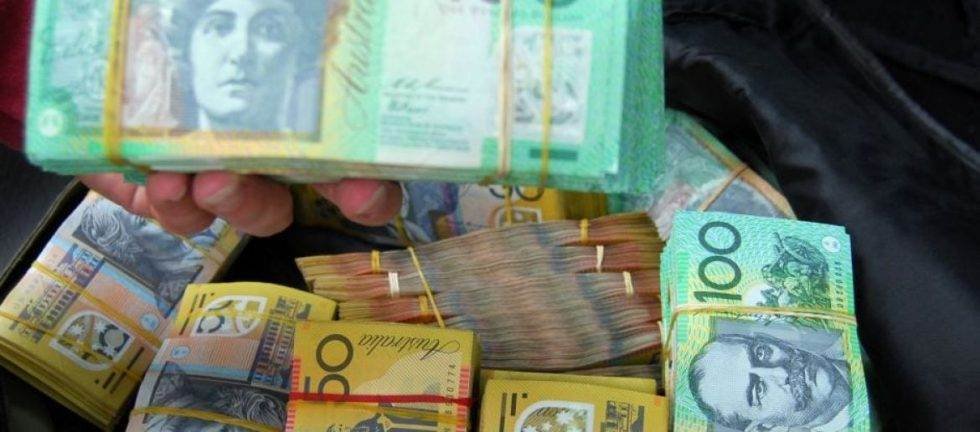 Stacks of Australian dollar banknotes bundled with rubber bands.