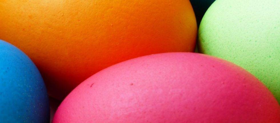 Close-up of colorful Easter eggs in pink, orange, green, and blue.