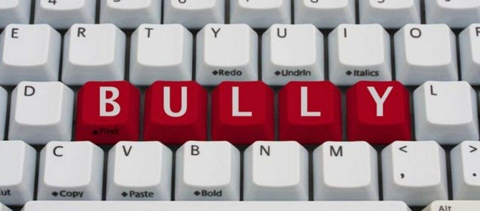 Keyboard with red keys spelling out "BULLY," illustrating online bullying and its impact.