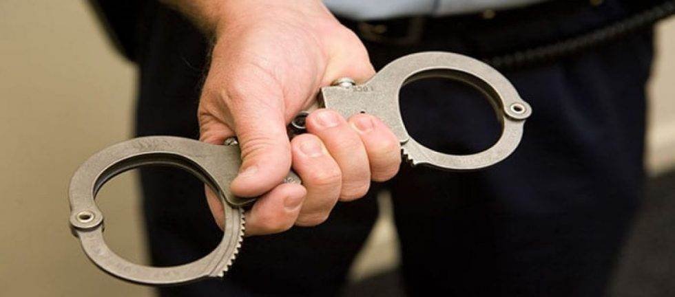 Close-up of hands holding handcuffs