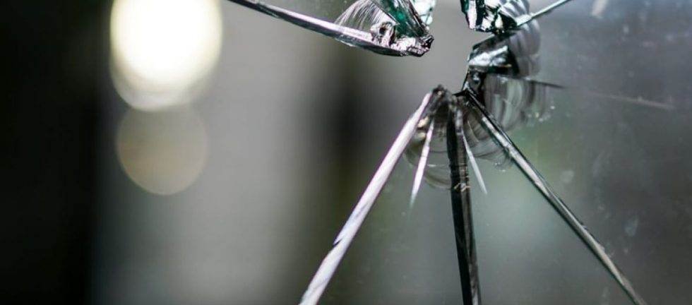Shattered glass, radiating cracks from impact point. Home invasion self-defense.