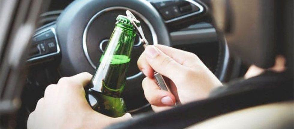 Person opening a beer bottle while driving.