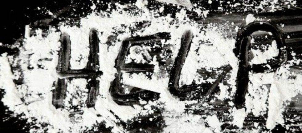 The word HELP written in white powder on a dark surface.
