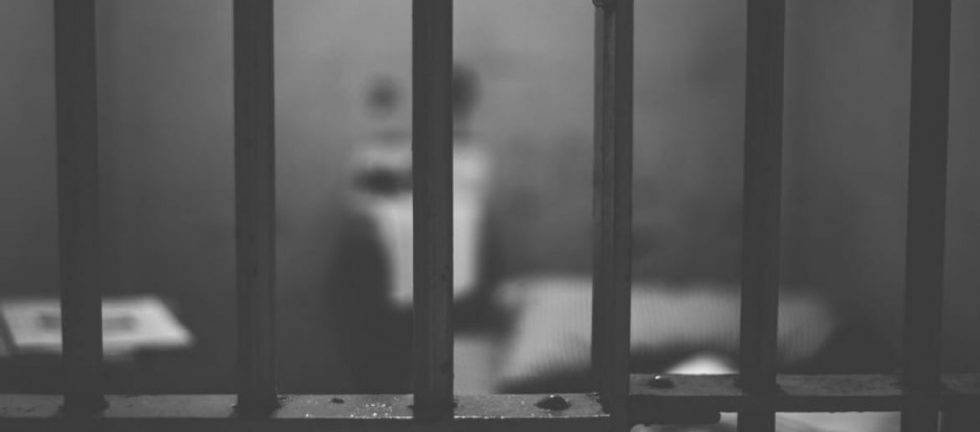 Blurred view through prison bars; questioning prison's effectiveness as punishment.