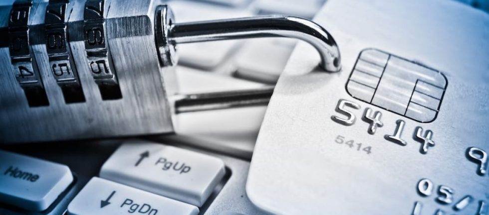 Padlock securing credit card on keyboard; online security