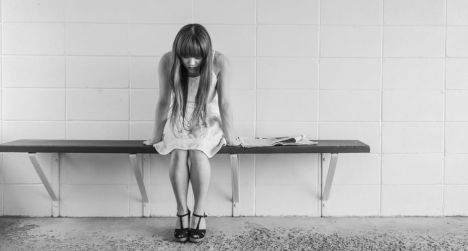 Sad young woman sitting on a bench