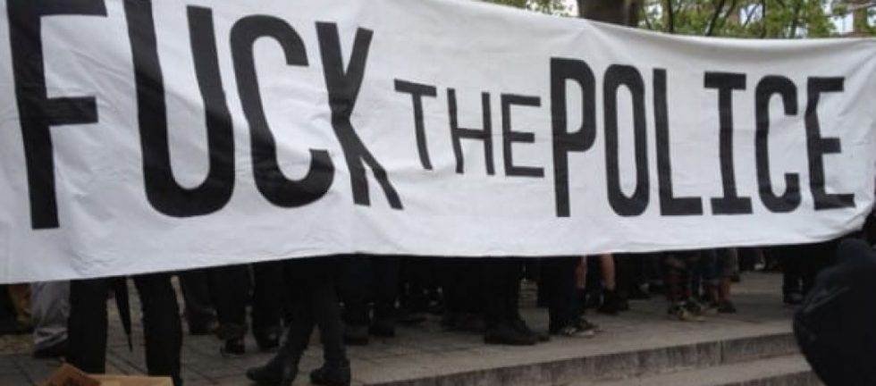 Protestors holding a "F*** the Police" banner.