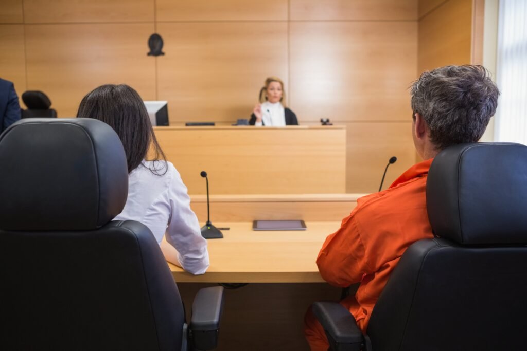 Defendant in orange jumpsuit and lawyer in court during a bail application hearing in NSW.