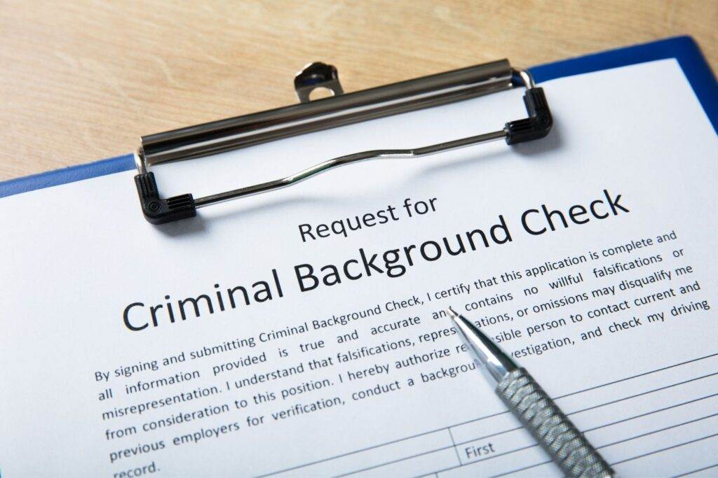 Criminal background check request form with pen. NSW criminal record information.