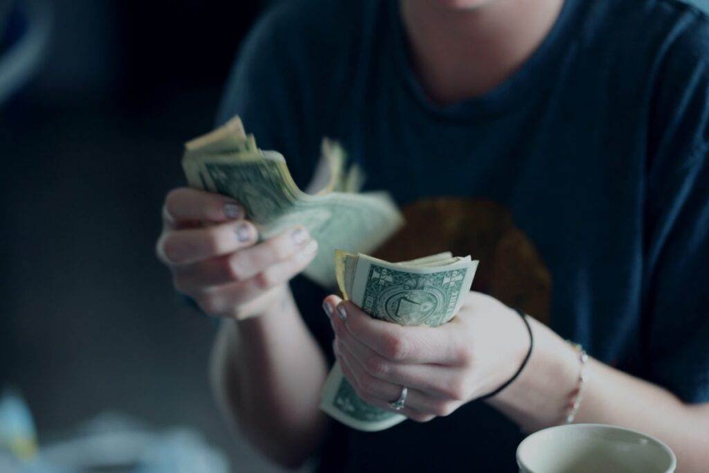 Person counting money, illustrating financial deception.