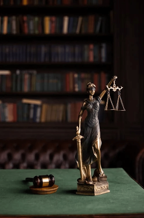 Statue of Lady Justice and a gavel on a table, symbolizing NSW court system principles.