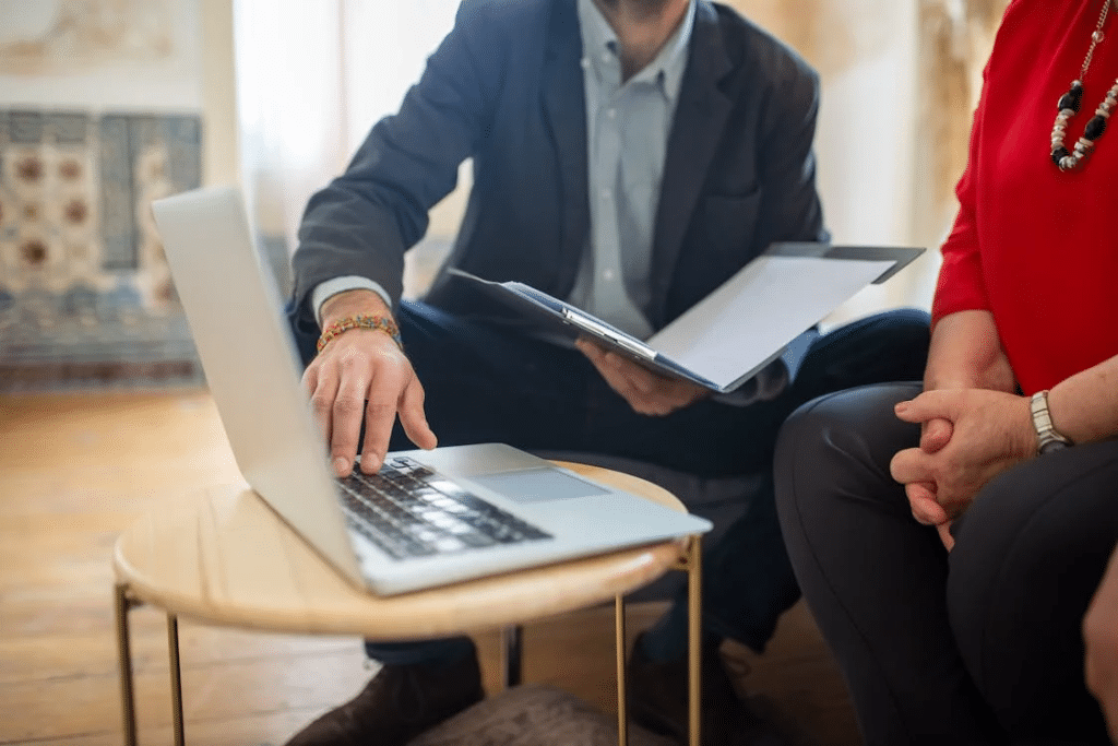 Two people discuss NSW child witness court protections using a laptop and notepad.