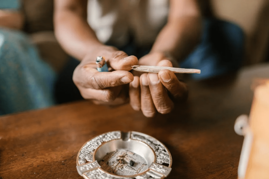 Hands holding a joint with an ashtray nearby, representing NSW drug possession charge defence context.
