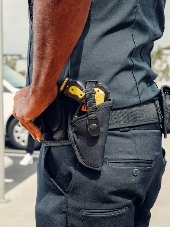 Police officer with Taser in holster, highlighting NSW legal use guidelines and rights against unlawful Taser use.