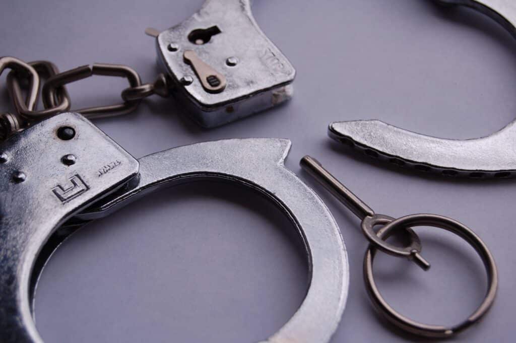 Close-up of handcuffs with a key, symbolizing legal restrictions. Explore Intensive Correction Orders in NSW.