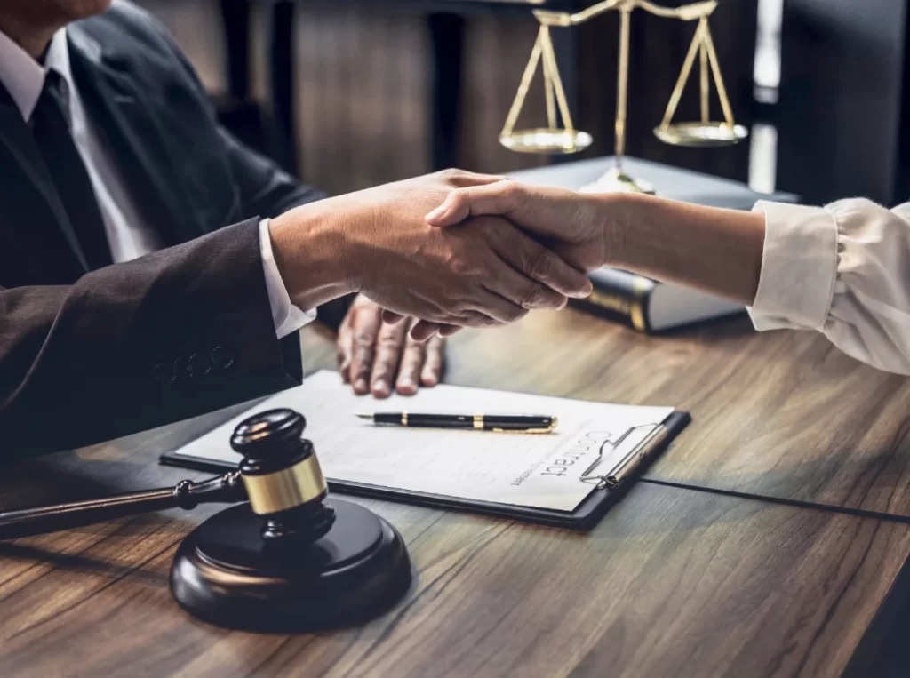Two people shake hands over a legal document with a gavel and scales, symbolizing consorting laws in NSW.