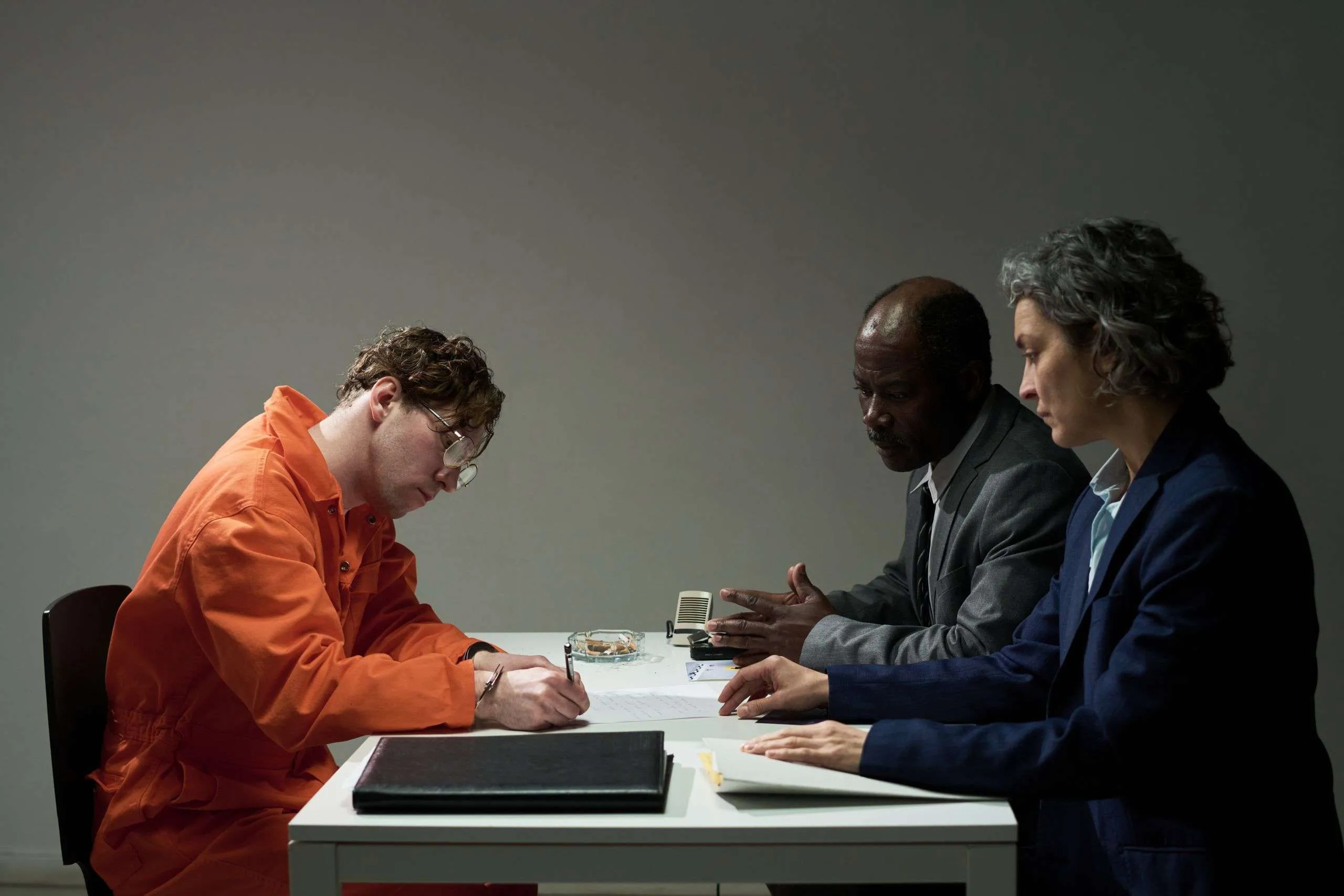 Inmates and lawyers discuss sentencing discounts in NSW during a legal consultation at a table.
