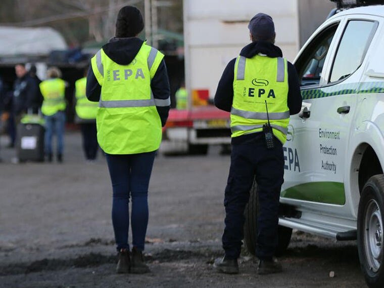 NSW EPA officers in high-visibility vests assess environmental compliance near an agency vehicle.