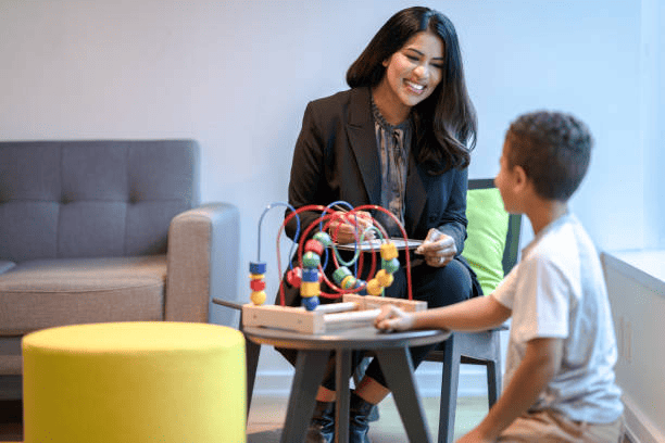Woman interacting with a child in a playroom, highlighting the importance of a working with children check.