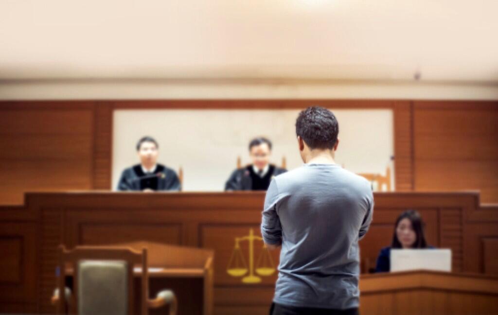 Man stands before judges in a courtroom, representing a fail to appear court case in NSW.