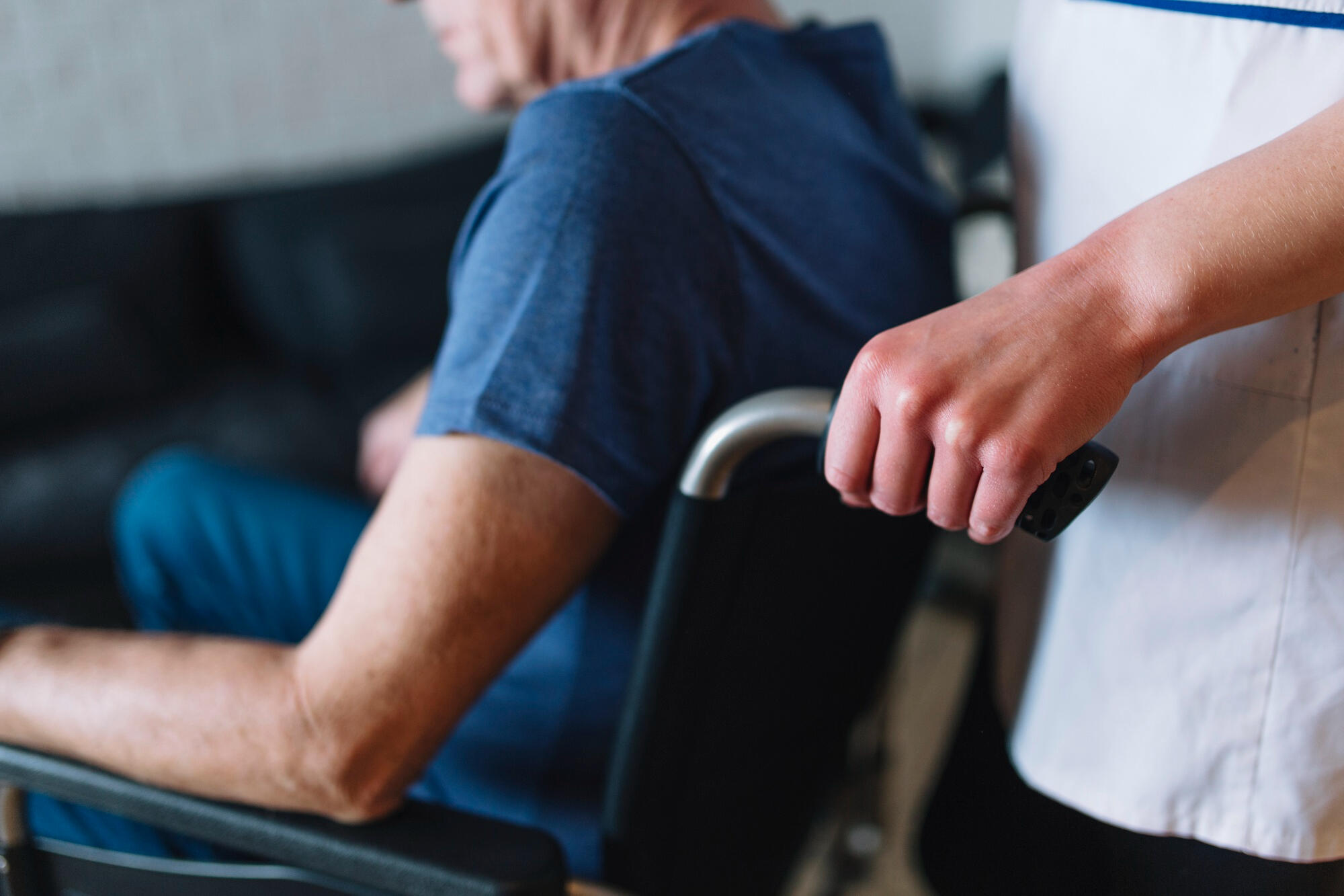 Person in a wheelchair with a caregiver, reflecting themes of euthanasia legality in Australia.