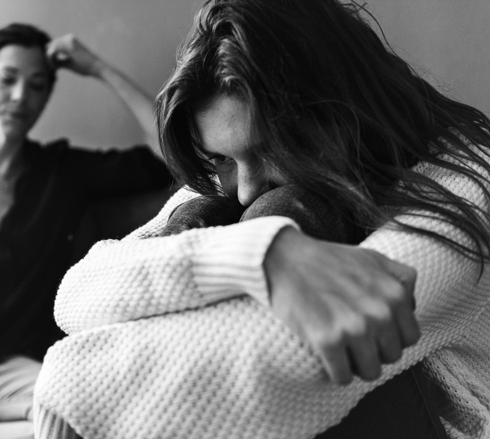 Woman in distress hugging knees, suggesting sexual assault concerns and pre-existing relationship with the accused.