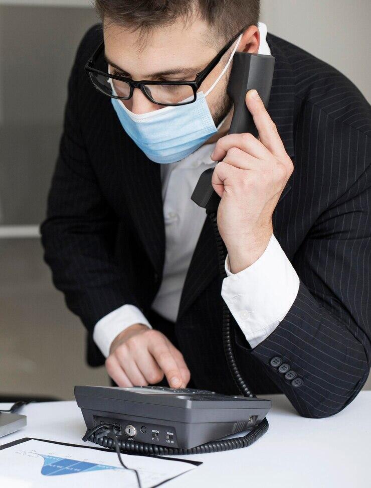 Man in suit making a phone call, highlighting risks and penalties for prank calling emergency services.