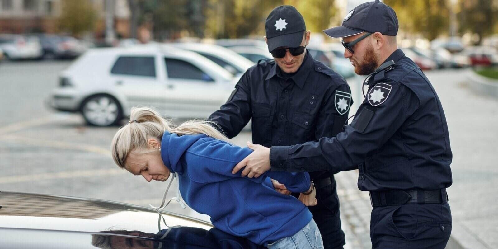 Police officers detain a woman by a car, illustrating entrapment in NSW.