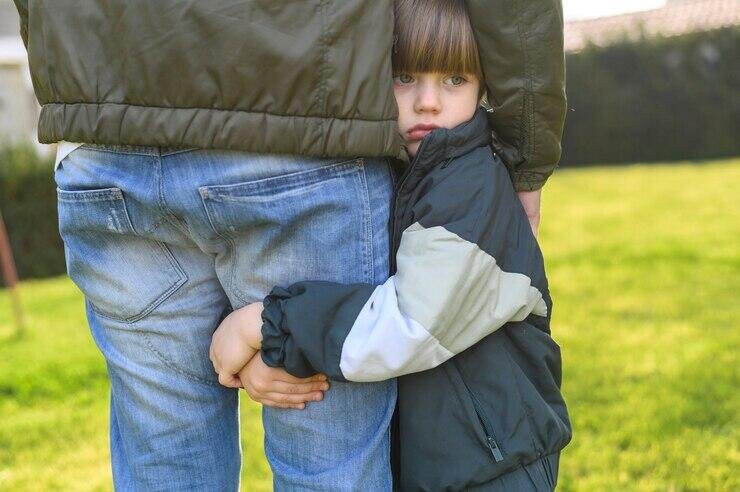 Child hugging father's leg, seeking comfort and protection. Apprehended Violence Order (AVO).