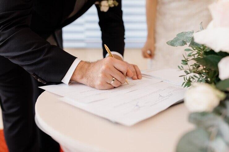 Groom signing wedding documents, NSW marriage laws.