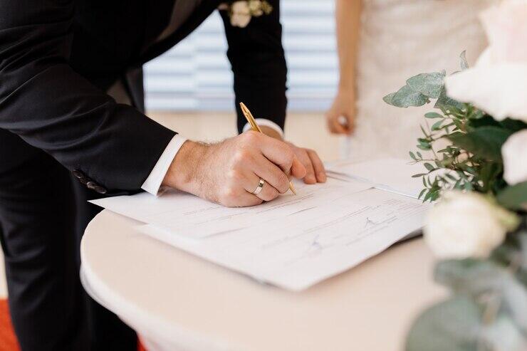 Groom signing wedding documents, NSW marriage laws.