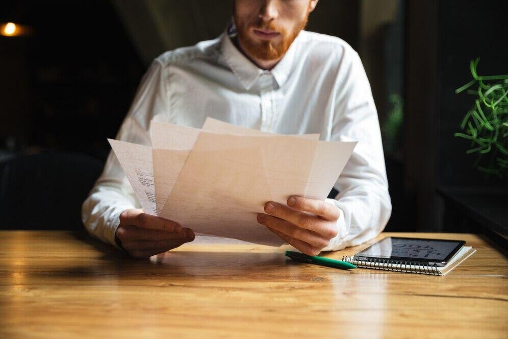 Close-up of a person reviewing documents. Potential NSW penalties for using false documents are a serious concern.