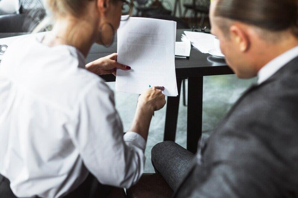 Two professionals review legal documents during a NSW court trial consultation.