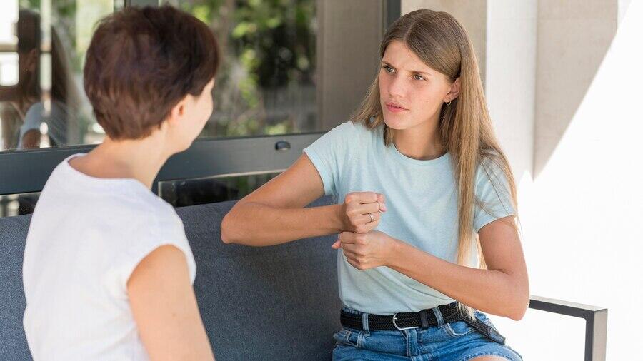 Two women conversing, one using sign language. Understanding your rights in NSW.