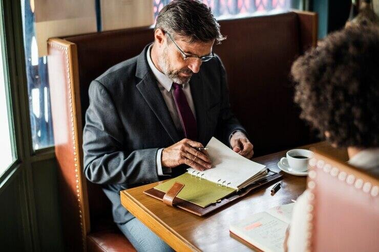 Businessman reviewing documents at a cafe table, considering an appeal of an unfair NSW Local Court sentence.