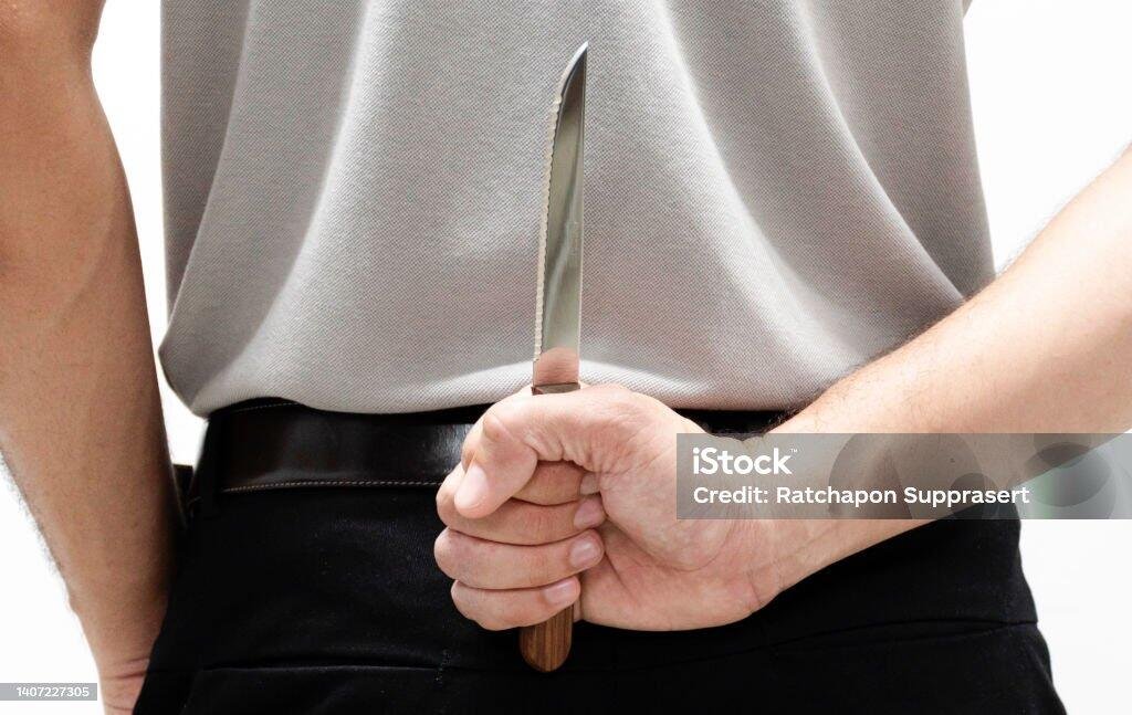 Person hiding a knife behind their back. NSW knife laws.