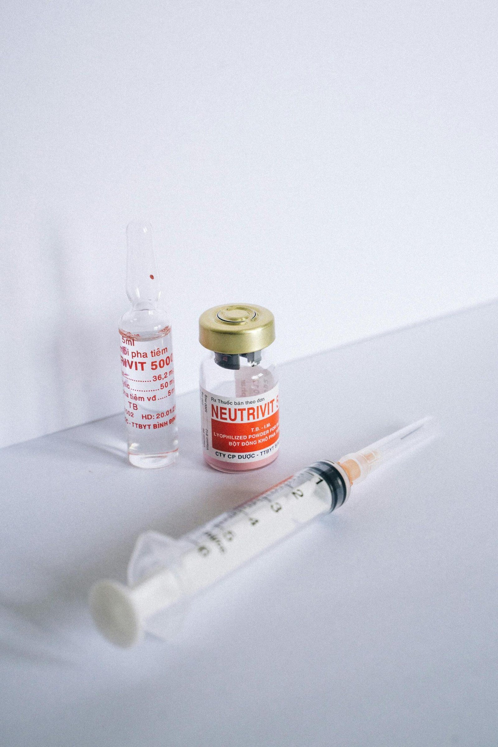 Close-up of syringes and vials labeled "NEUTRIVIT" and "RVIT 5000," potentially related to prohibited drug administration in NSW.