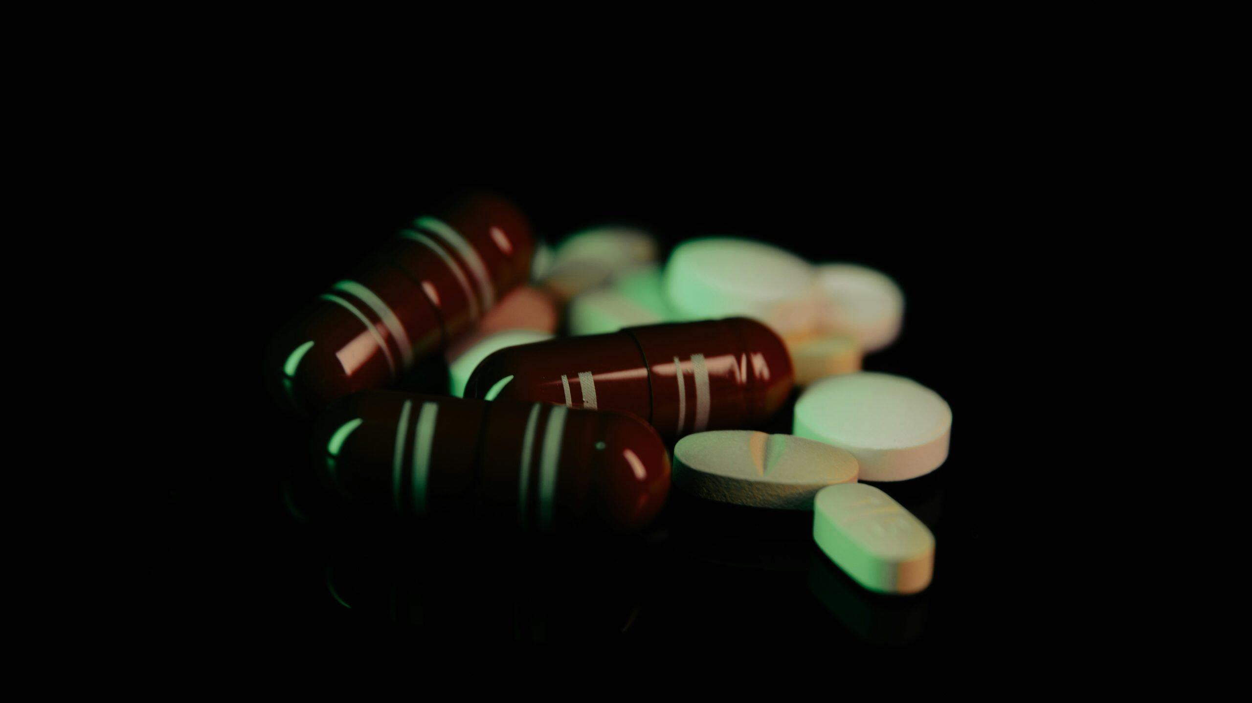 Close-up of various pills and capsules, possibly related to drug supply offences in NSW.