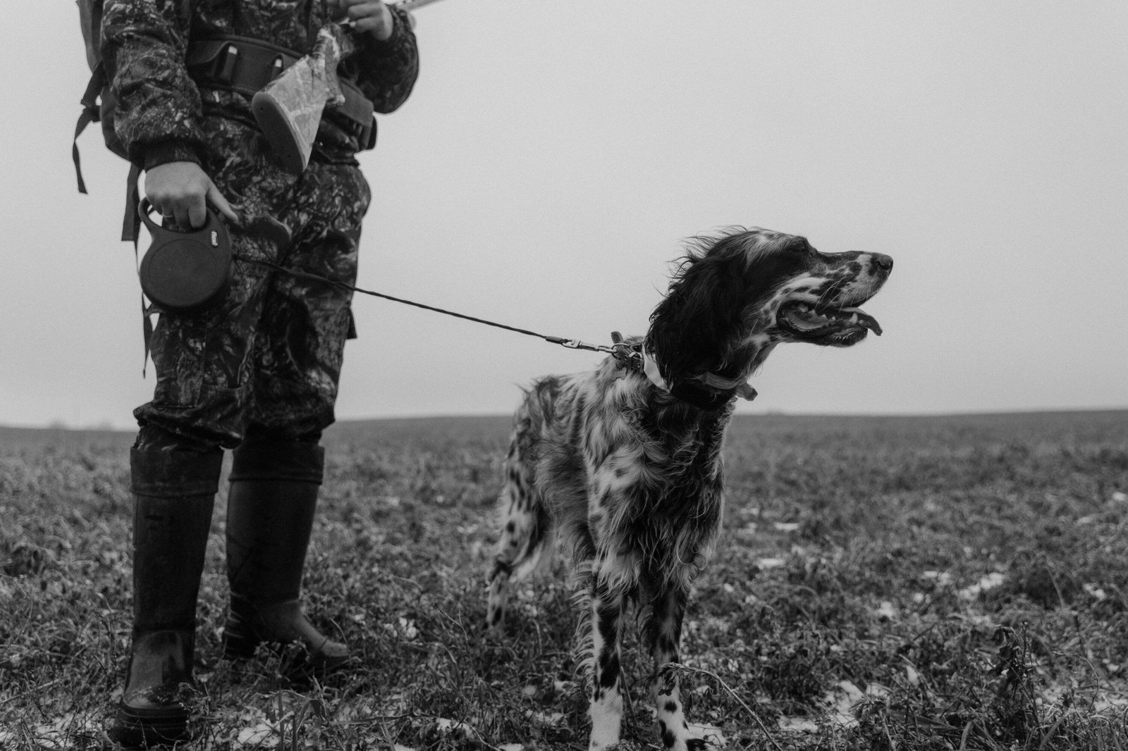 Hunter with English Setter dog in snowy field