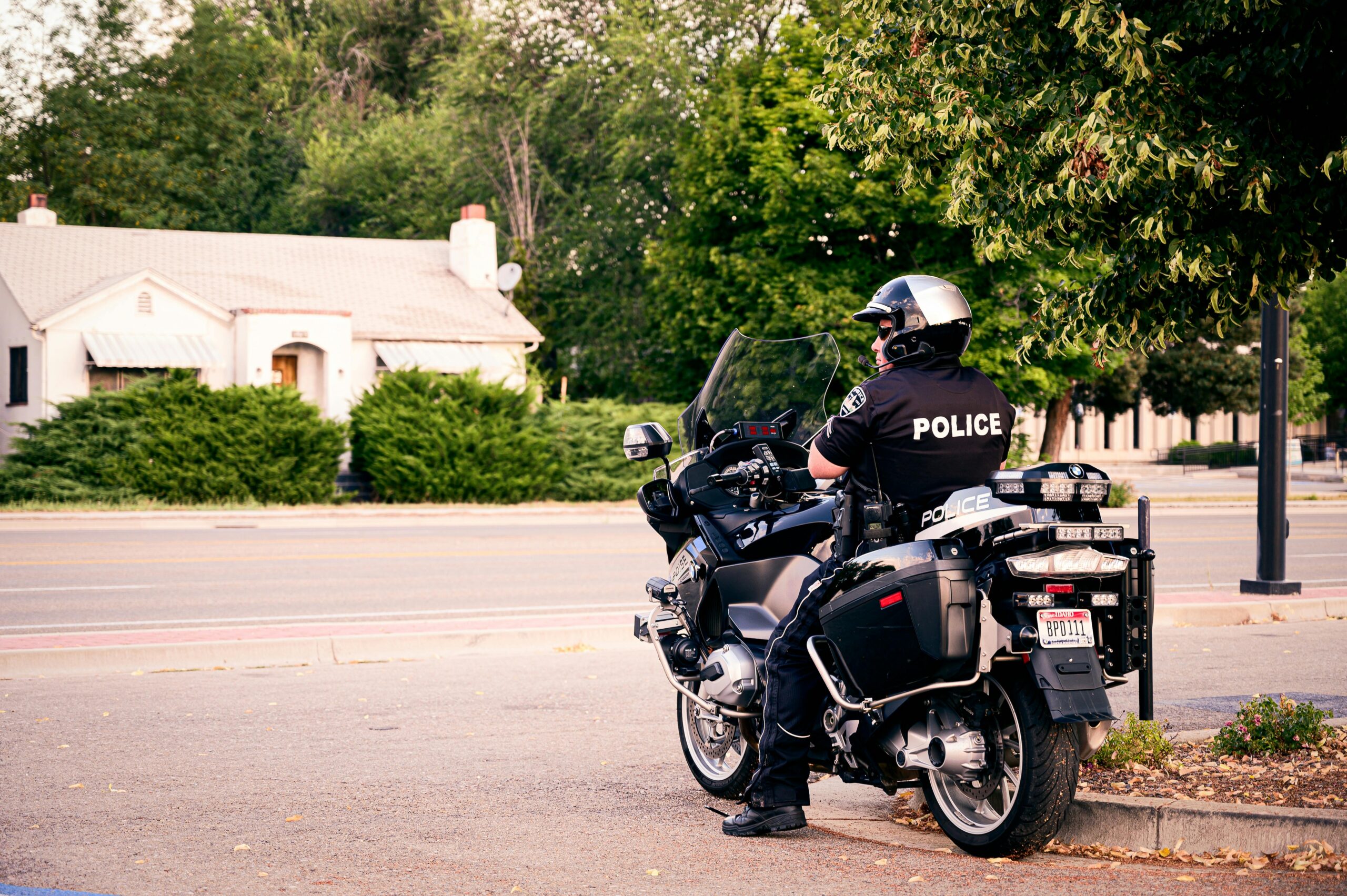 Police officer on motorcycle, parked on city street.